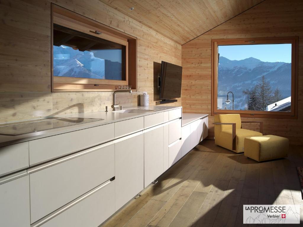 a kitchen with a sink and a large window at Chalet "La Promesse" in Bagnes