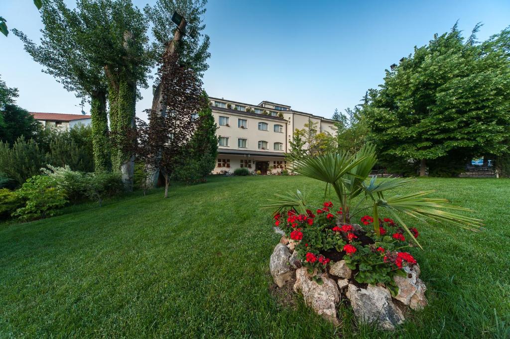 una casa con un jardín con flores en un patio en Albergo La Primula, en Potenza