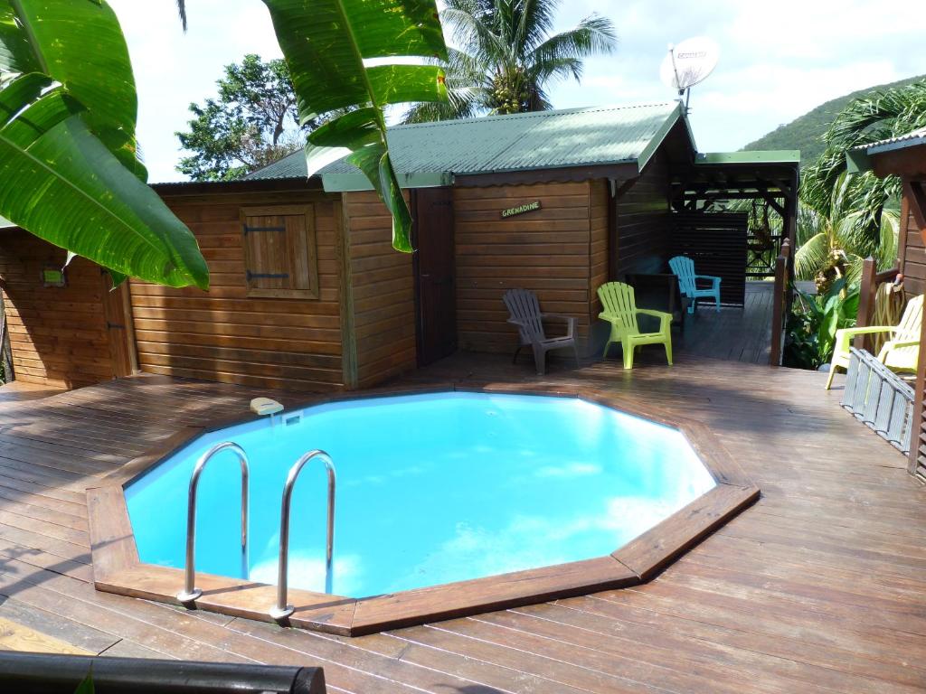 einen Pool auf einer Terrasse mit einem Haus in der Unterkunft les hauts de deshaies in Deshaies