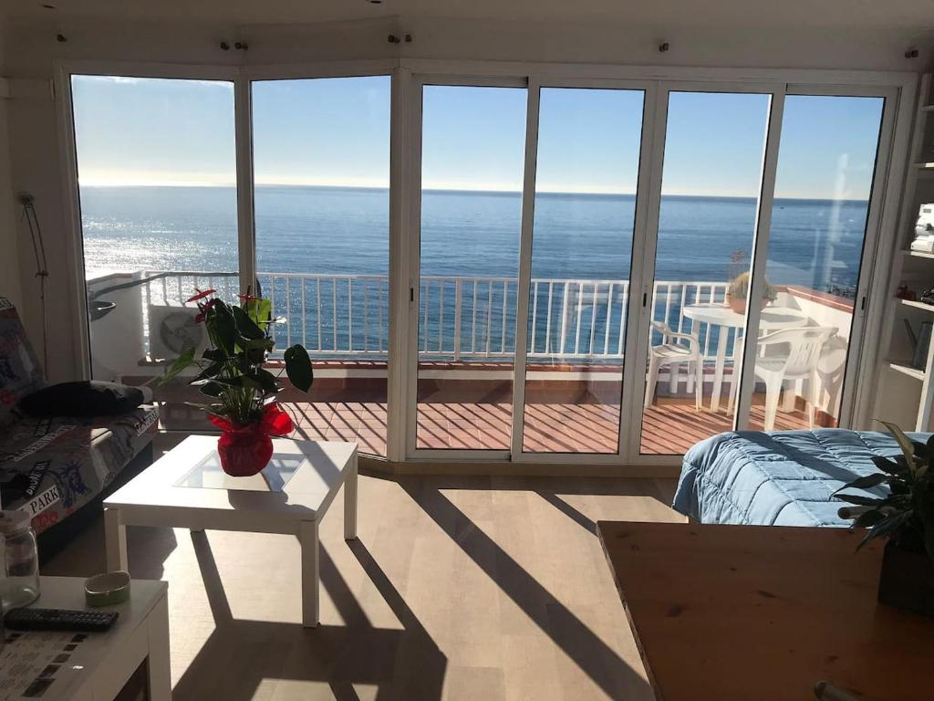 a bedroom with a view of the ocean from a balcony at Espectacular apartamento cerca de Barcelona con free wifi in Canet de Mar