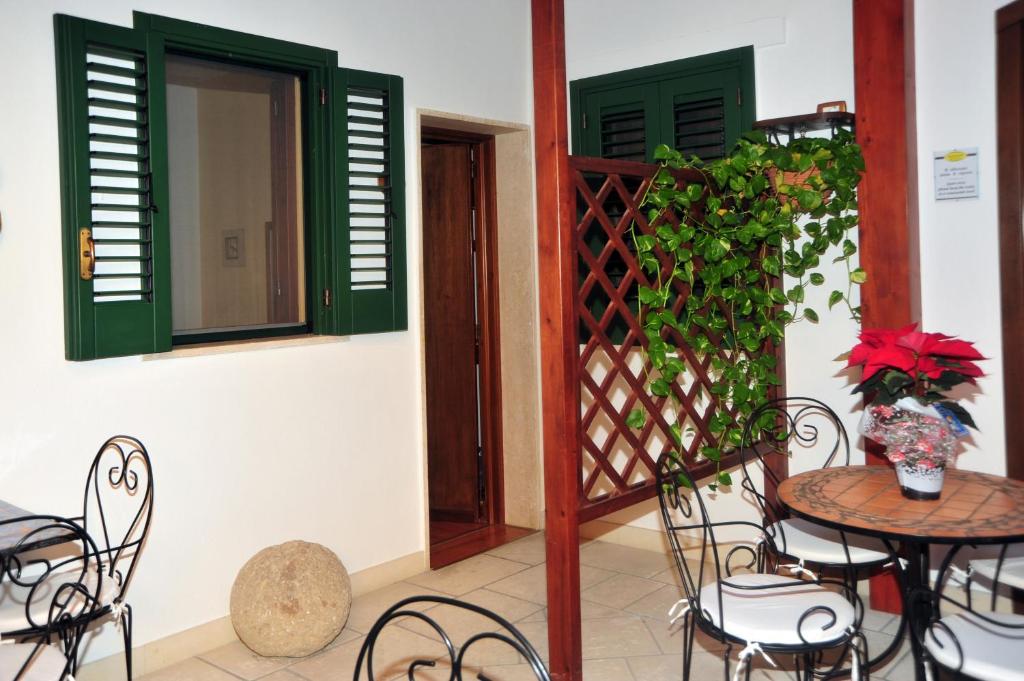 patio ze stołem, krzesłami i zielonymi drzwiami w obiekcie B&B Viaprimaldo Camere w mieście Otranto