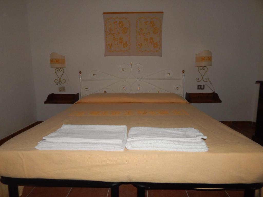 a bedroom with a bed with two white towels on it at Residence Spiaggia Bianca in Golfo Aranci