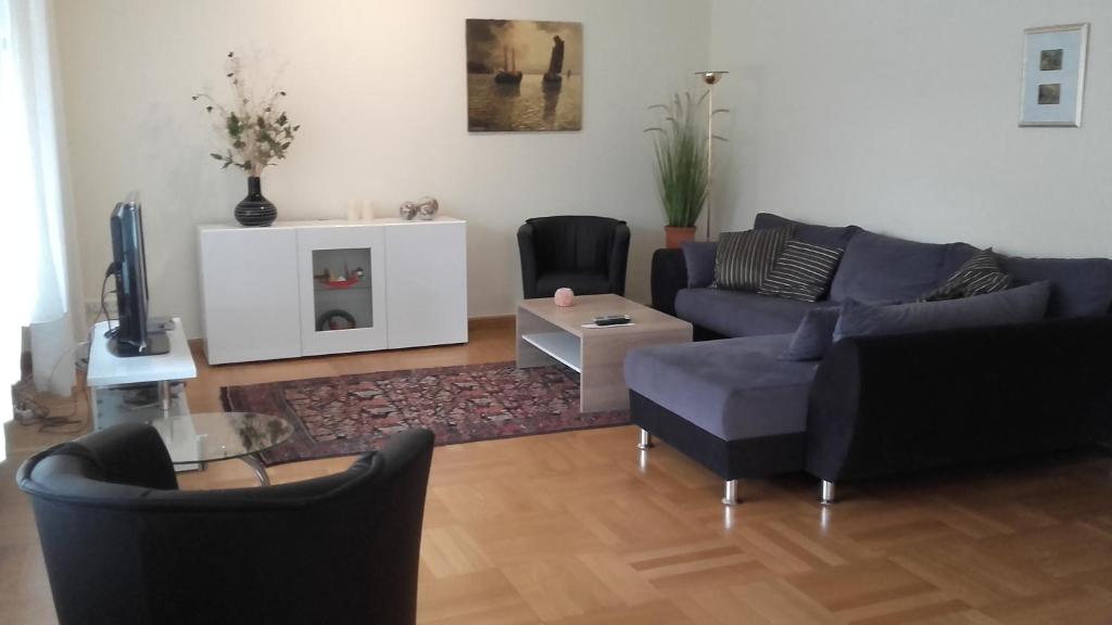 - un salon avec un canapé, des chaises et une télévision dans l'établissement Ferienwohnung Bea in Rheine, à Rheine