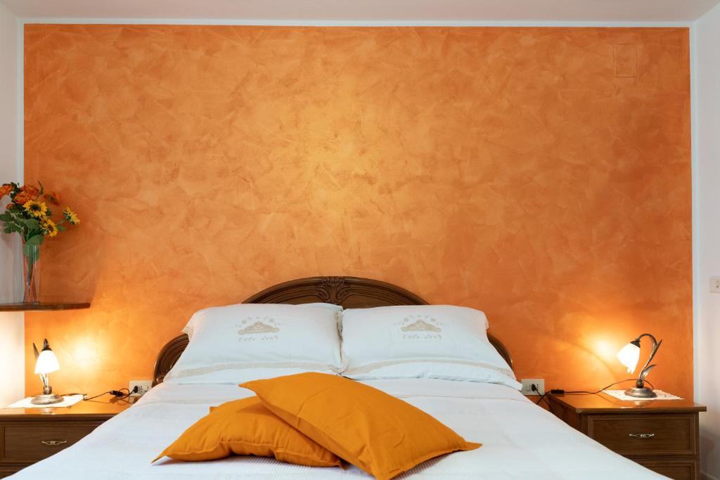 a bed with white sheets and yellow pillows at La Bouganville di Sante e Rosa in Manoppello