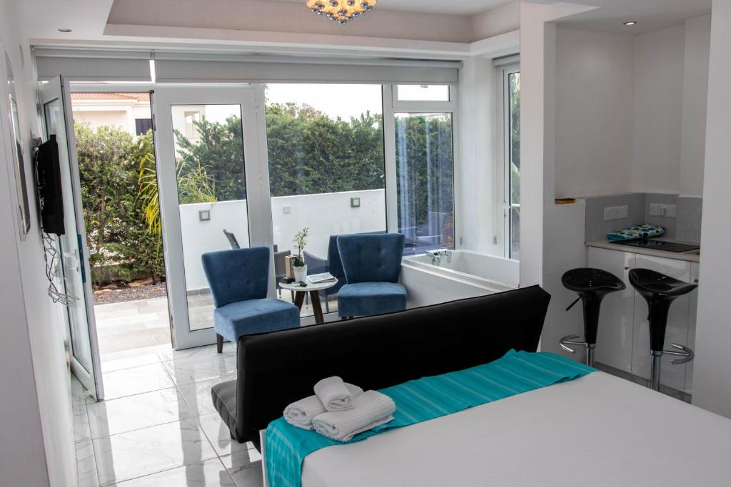a bedroom with a bed and two blue chairs at Nissi49 Apartments in Ayia Napa