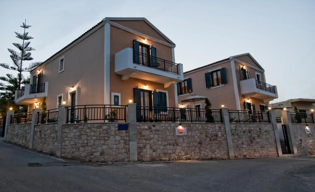 a large house on a stone wall with a fence at Crete Residence Villas in Panormos Rethymno