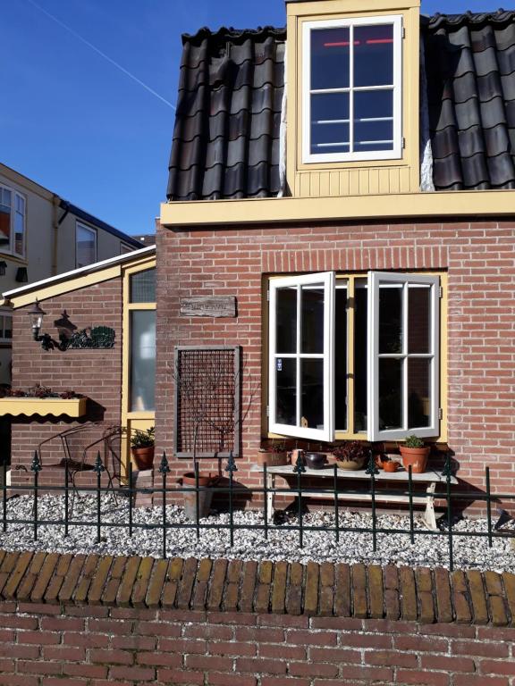 a brick house with a fence in front of it at Huisje De Koning in Zandvoort