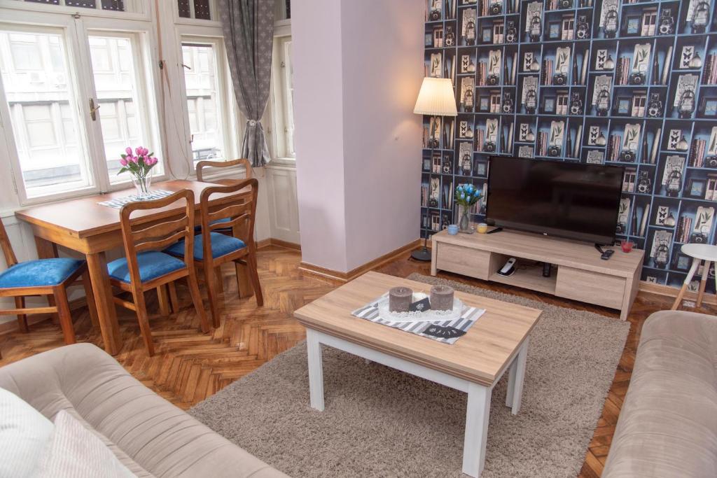 uma sala de estar com uma mesa e uma televisão em Sweet House Trg em Belgrado