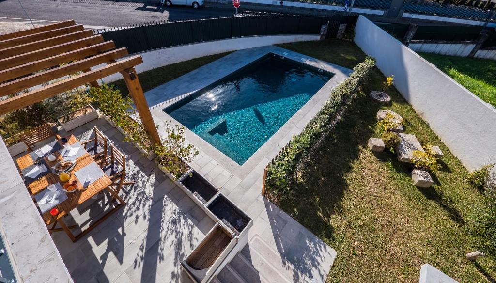 an overhead view of a swimming pool with a bench at BeGuest Sun & Pool House in Parede