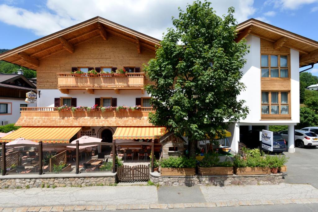 a building with a tree in front of it at Café Pension Koller in Brixen im Thale