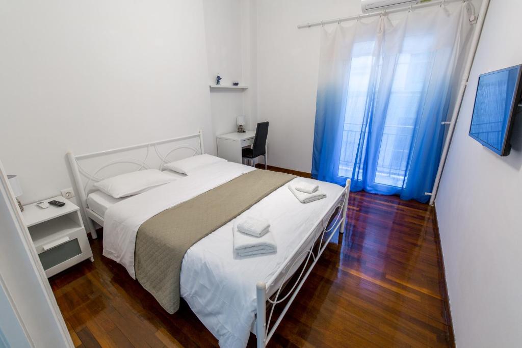 sypialnia z dużym białym łóżkiem i oknem w obiekcie ALKAMENOUS APARTMENT PETROS vipgreece. w Atenach