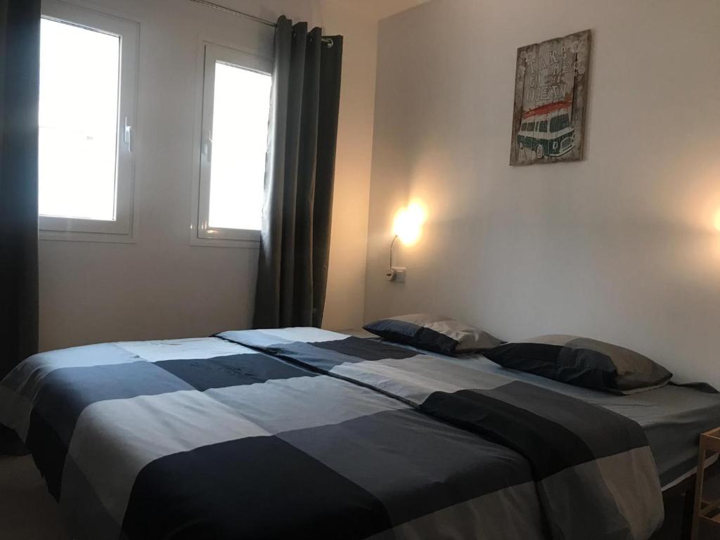sypialnia z dużym łóżkiem i 2 oknami w obiekcie Nice and sunny apartment w Corralejo