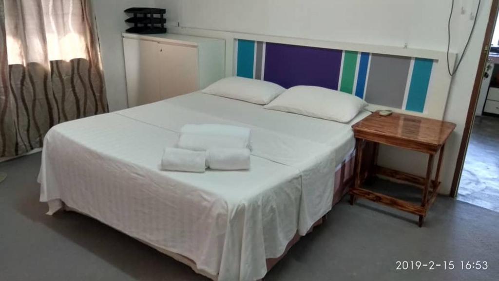 a bedroom with a large bed with two pillows on it at MYHome@Langkawi in Pantai Cenang