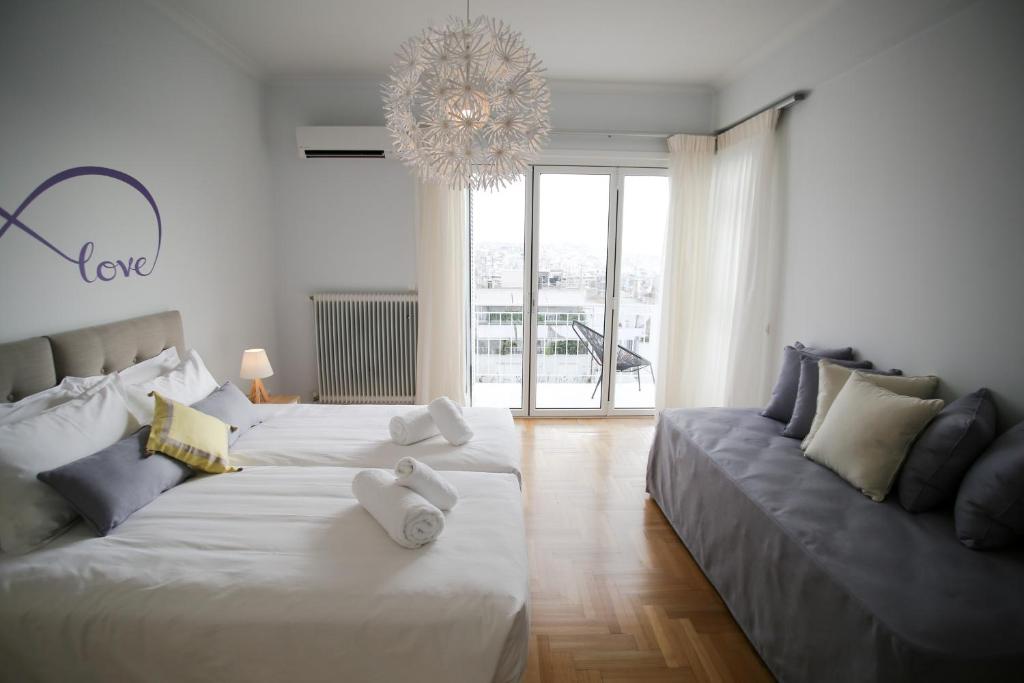 ein Wohnzimmer mit 2 Betten und einem Sofa in der Unterkunft Bluscapes Home in Athen