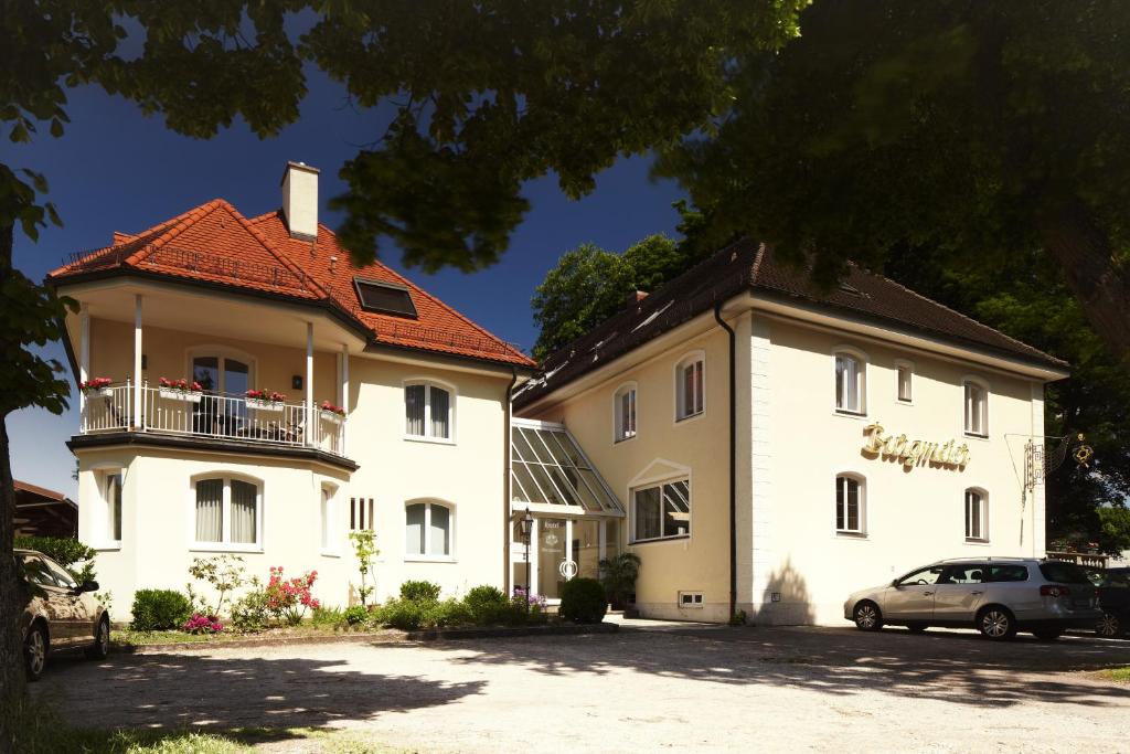 un gran edificio blanco junto a un edificio más pequeño en Hotel Burgmeier, en Dachau