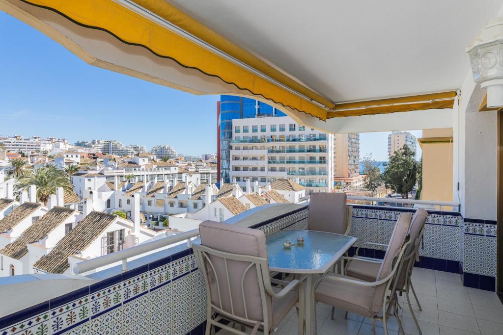 ベナルマデナにあるgran apartamento en la costaの市街の景色を望むバルコニー(テーブル、椅子付)