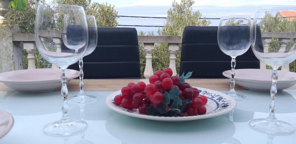 een tafel met drie wijnglazen en een bord bloemen bij Apartment Sunrise in Stomorska
