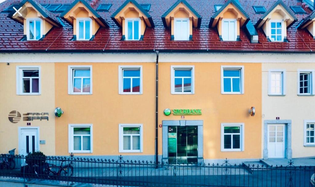 een groot geel gebouw met een rood dak bij Apartment Na skali in Kranj