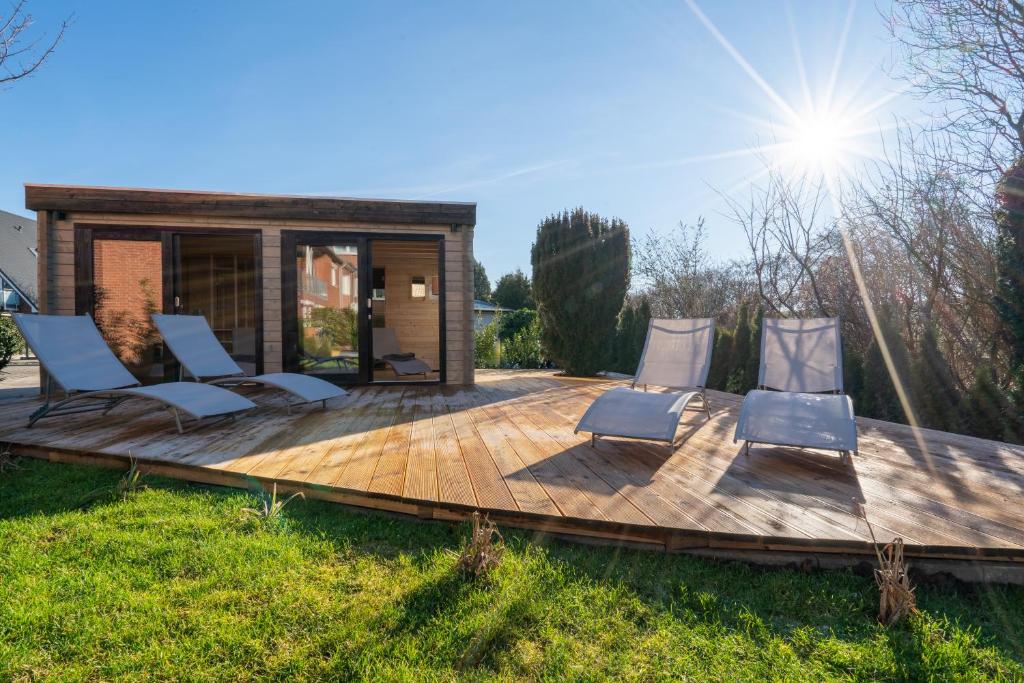 a wooden deck with chairs and a house at Diekhuus Büsum in Büsum
