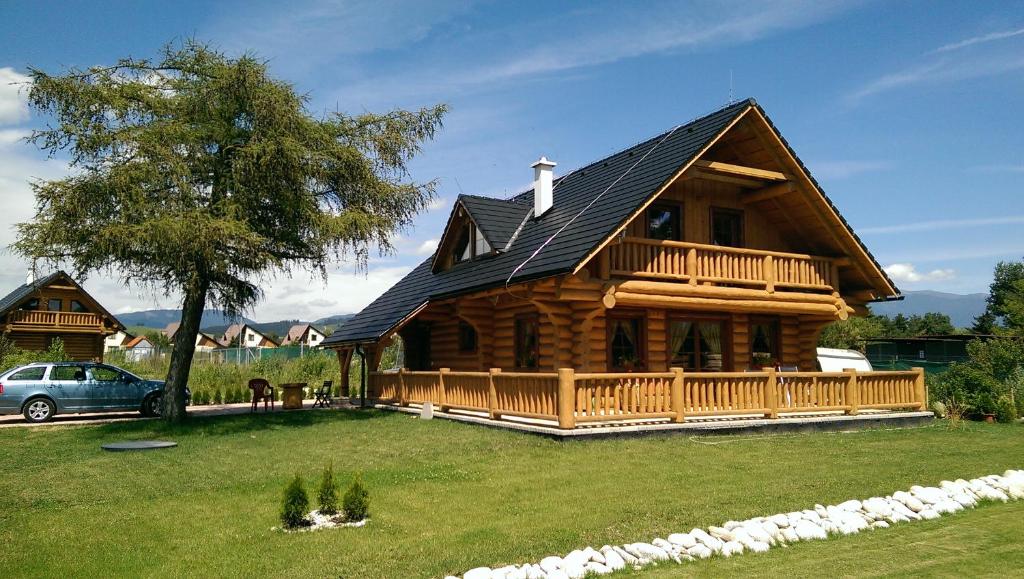 ein Blockhaus mit einer Veranda und einem Auto in der Unterkunft Rekreačný zrubový dom in Liptovský Trnovec