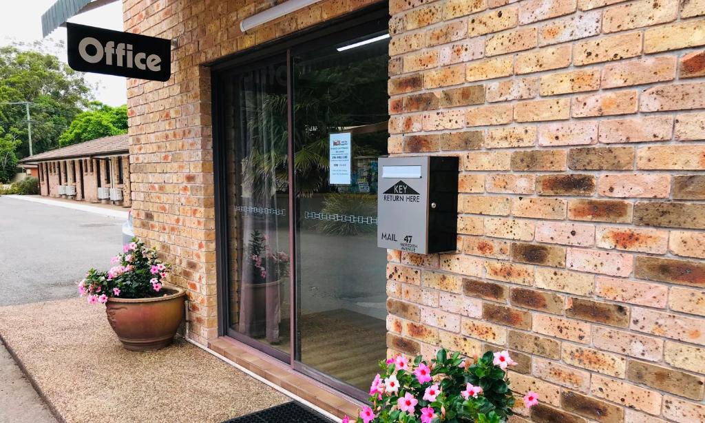 a brick building with a office sign on it at Lemon Tree Passage Motel in Lemon Tree Passage