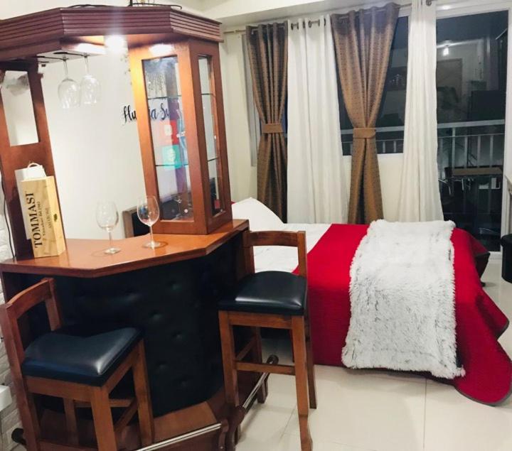 1 dormitorio con 1 cama, escritorio y sillas en Hunaja's Home at Wind Residences TAGAYTAY en Tagaytay