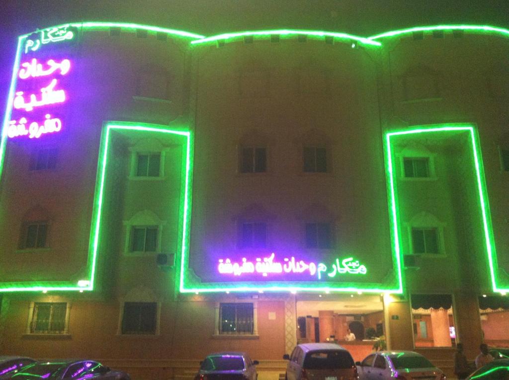 un edificio con insegne al neon sul lato di esso di Makarem Najd Funished Units 2 a Riyad