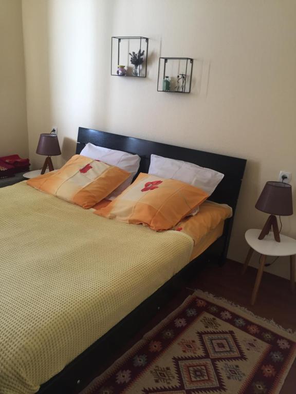 een slaapkamer met een bed met 2 lampen en een tapijt bij Golden Mount View Apartment in Goedaoeri