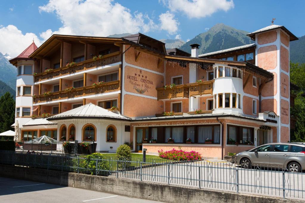 un edificio con un coche aparcado delante de él en Hotel Cristina en Pinzolo