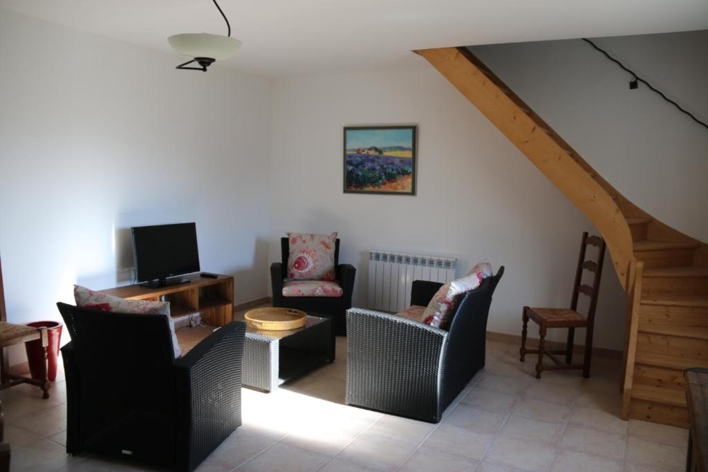 a living room with several chairs and a tv at 926 Chemin de Saint-Antoine in Violès