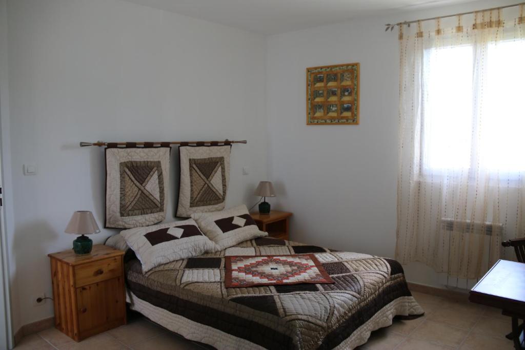 a bedroom with a large bed and a window at 926 Chemin de Saint-Antoine in Violès