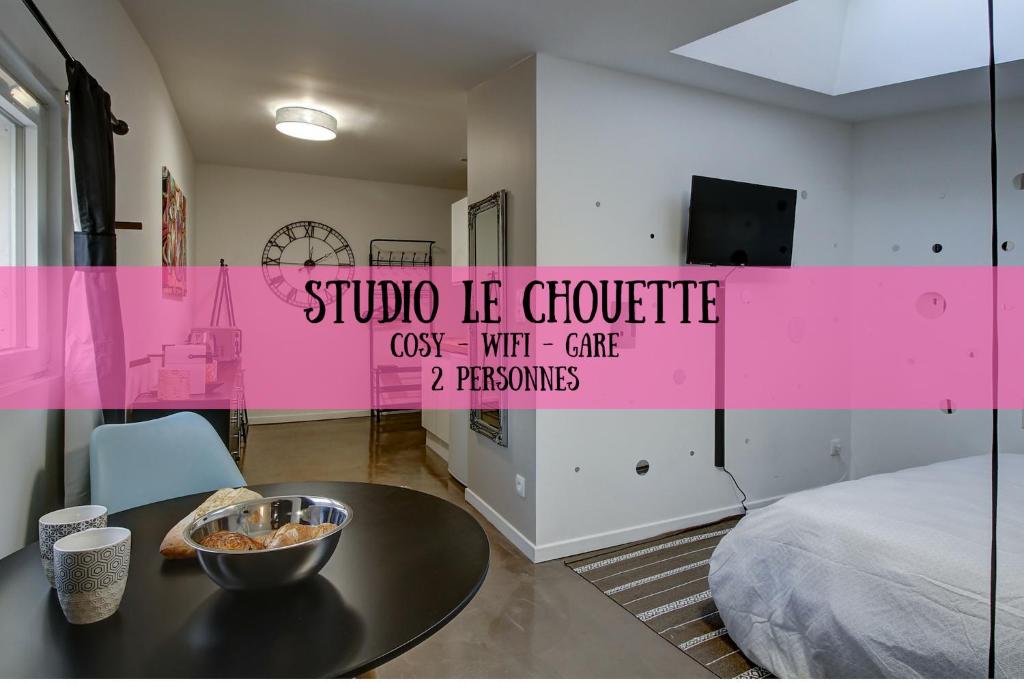 Zimmer mit einem Tisch und einer rosa Wand in der Unterkunft STUDIO LE CHOUETTE in Dijon