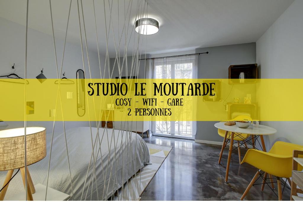 a room with a bed and a yellow wall at STUDIO LE MOUTARDE in Dijon