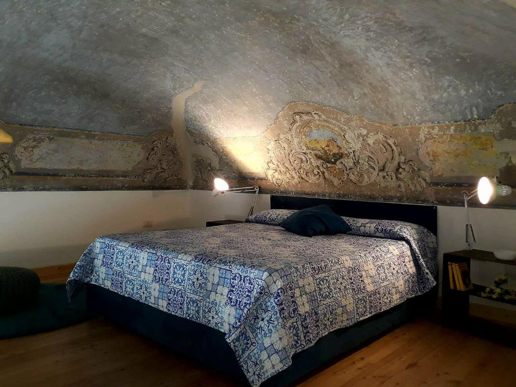 - une chambre avec un lit orné d'une peinture murale dans l'établissement Naturalliving, à Catane