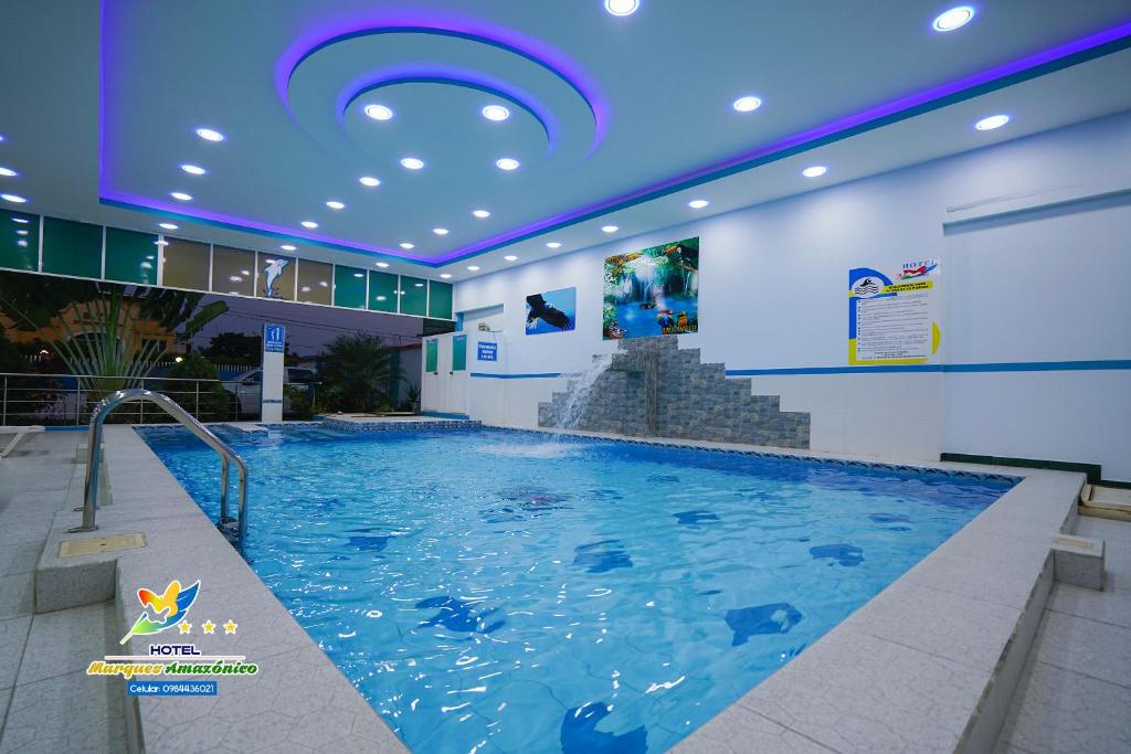 新洛哈的住宿－Hotel Marques Amazonico，一座带蓝色天花板的大型室内游泳池