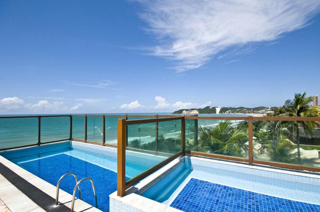 una piscina en un balcón con vistas al océano en Na praia - Araça 104 - Térreo frente mar, en Natal