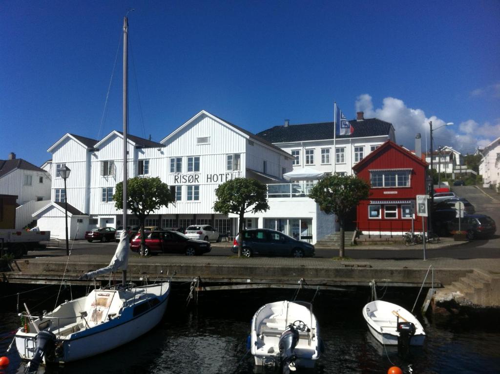 um grupo de barcos ancorados na água em frente a um edifício em Risør Hotel em Risør