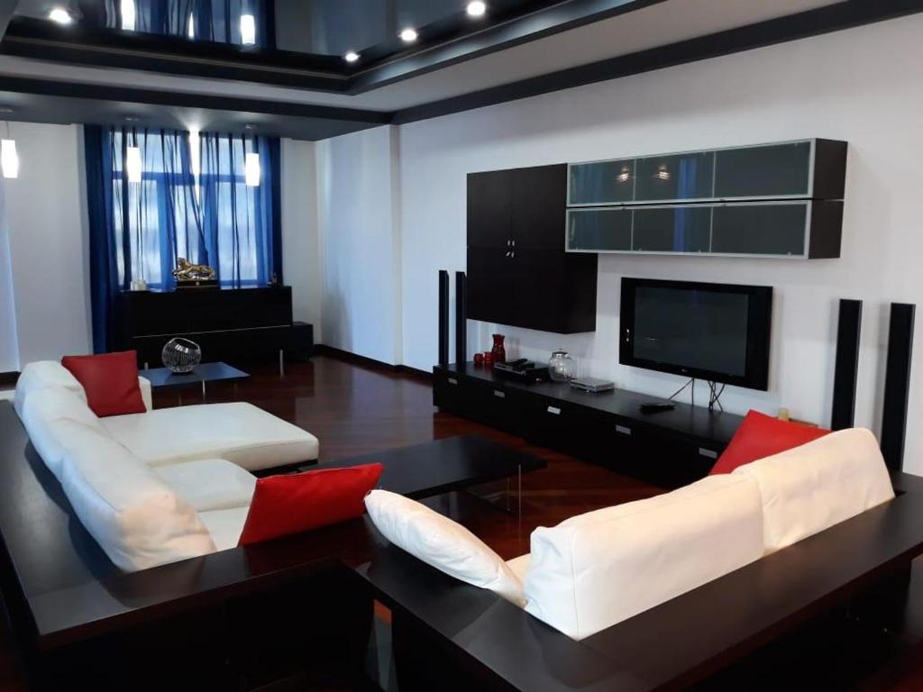 ein Wohnzimmer mit 2 weißen Stühlen und einem Flachbild-TV in der Unterkunft BAKU CITY CENTER 3. Bedrooms 3. in Baku