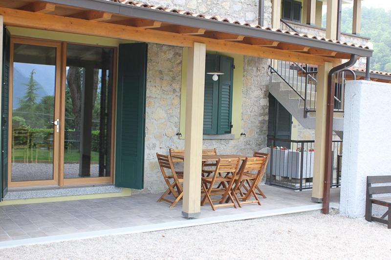 een houten tafel en stoelen op een patio bij Residence Elettra in Crone