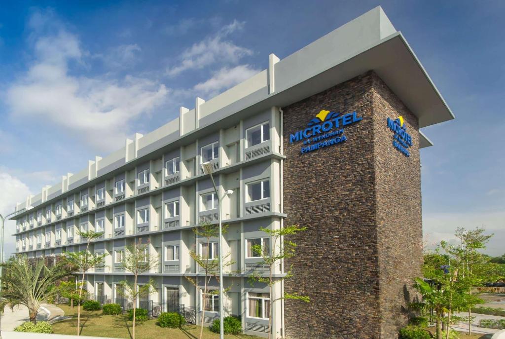 a building with a sign on the side of it at Microtel Inn & Suites by Wyndham San Fernando in San Fernando