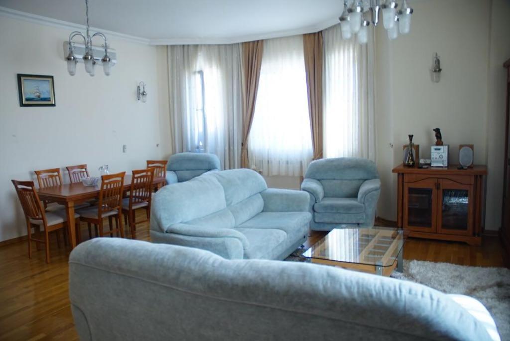 ein Wohnzimmer mit einem Sofa, Stühlen und einem Tisch in der Unterkunft Neftçilər prospekti . Bedrooms 2. in Baku