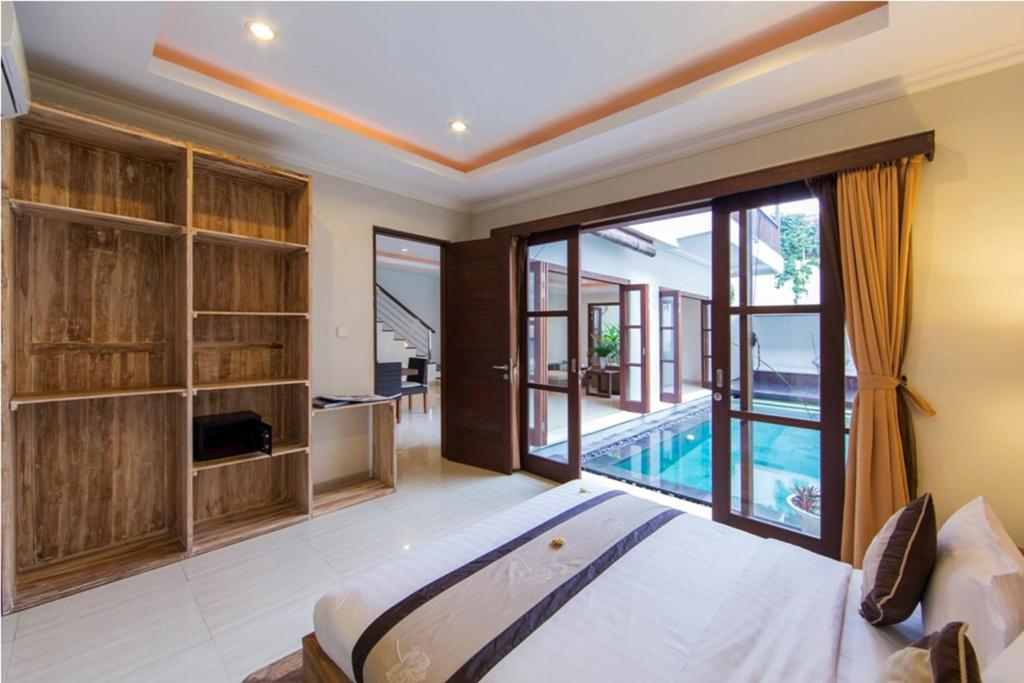 a bedroom with a large bed and a pool at White Lotus Villas Seminyak in Seminyak
