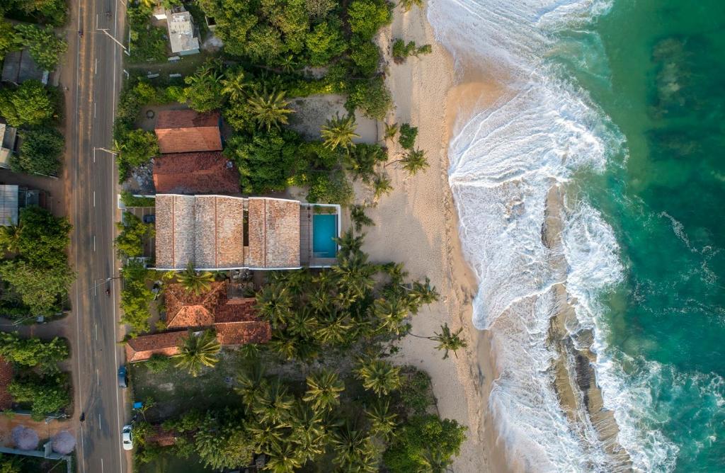 an overhead view of a beach with houses and the ocean at Three Gables Boutique Villa in Mirissa