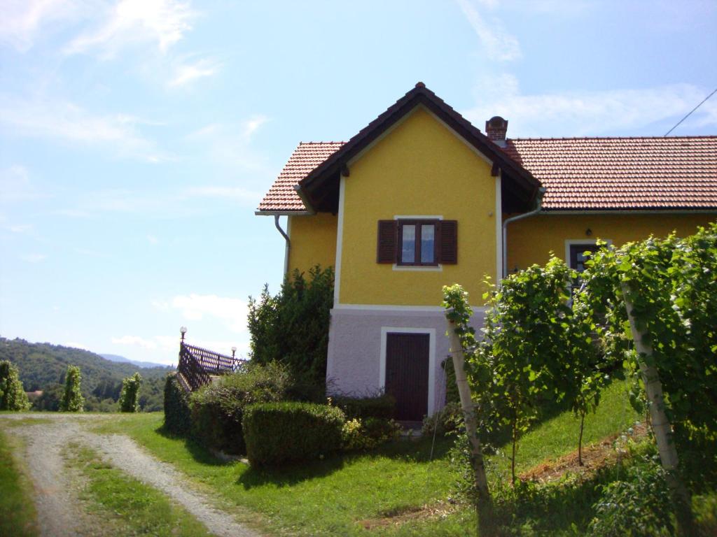uma casa amarela ao lado de uma estrada de terra em Ferienhaus Weingut Bauer em Gamlitz