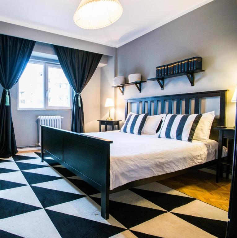 a bedroom with a large bed with blue curtains at Downtown Wonder Apartament in Cluj-Napoca