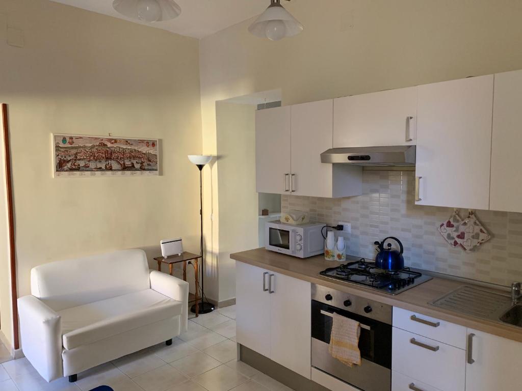 a kitchen with white cabinets and a stove top oven at La Piccola Reggia in Naples