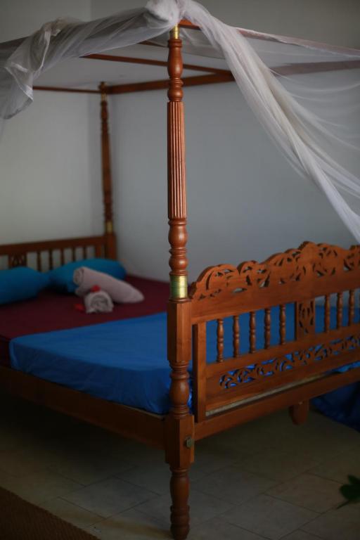 
a bed that has a canopy over it at Surfing Wombats in Weligama
