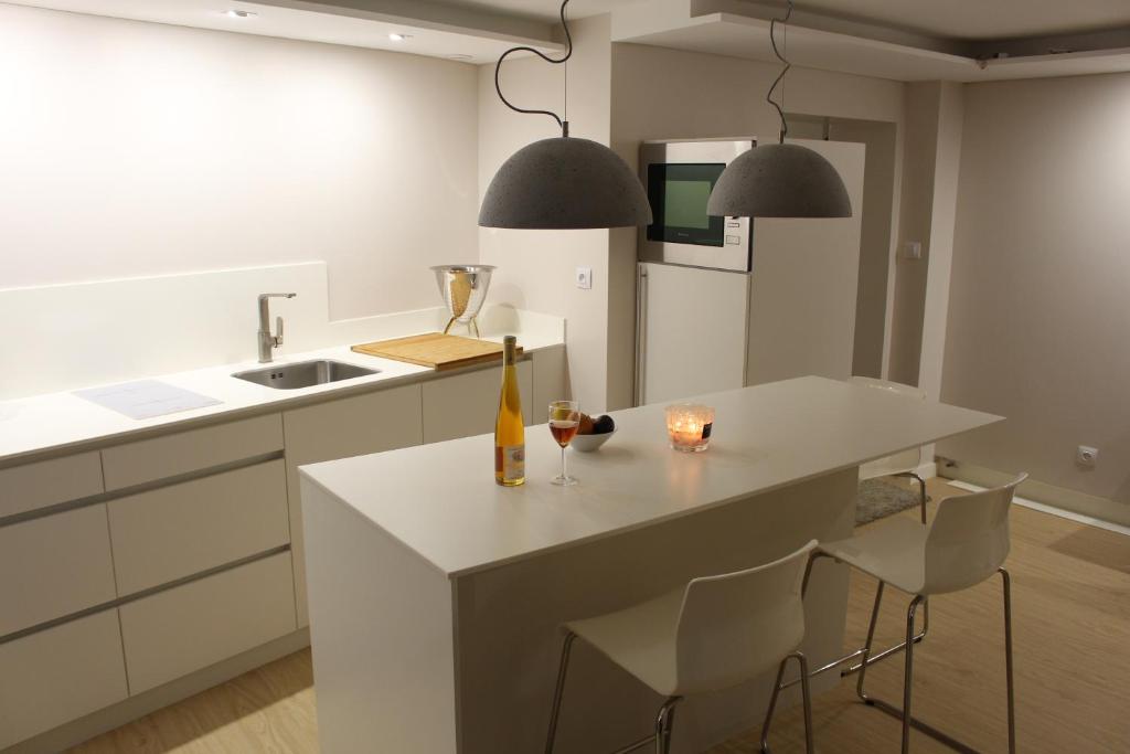 uma cozinha com uma ilha branca com uma garrafa de vinho em Strasbourg Entzheim em Entzheim