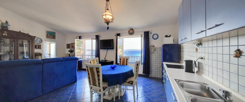 a kitchen with a blue table in a room at Apartments Rosso in Hvar