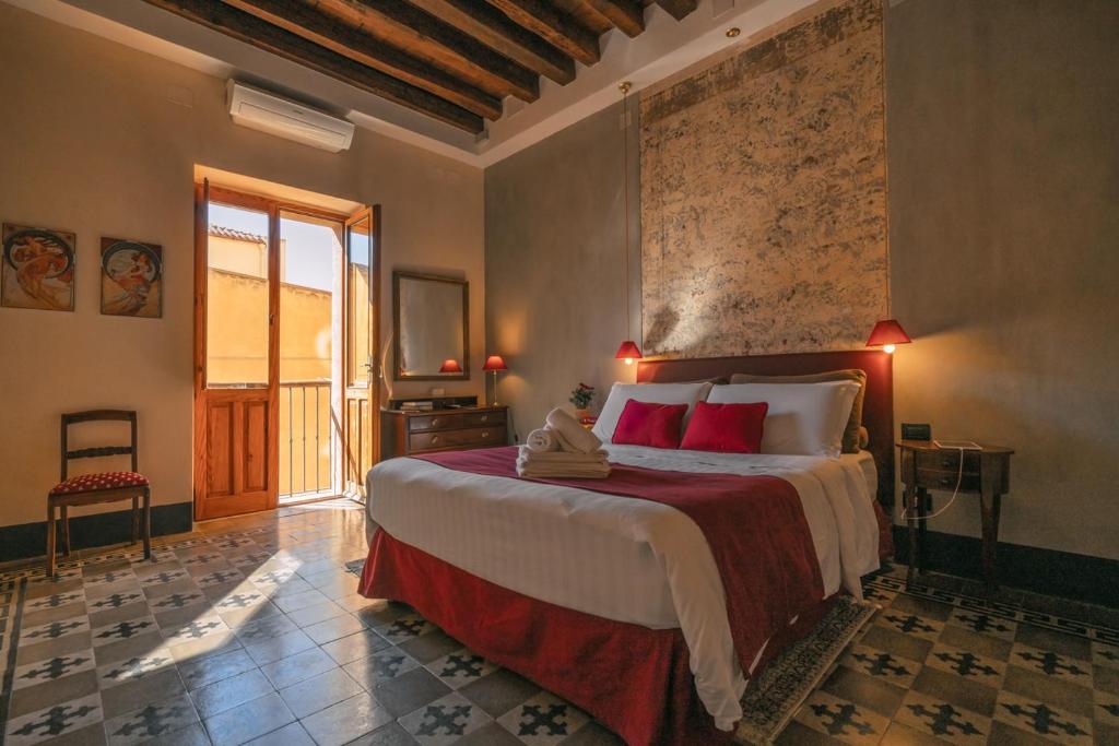 een slaapkamer met een groot bed met rode kussens bij B&B Cappuccine in Cagliari